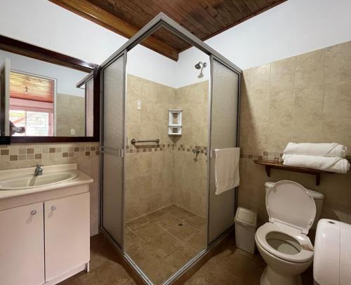 a bathroom with a shower and a toilet and a sink at Finca Hotel Santana in Montenegro