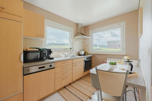 a kitchen with a table and a microwave at Chalet Panor'Anna in Saint-Vith