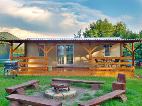 a cabin with picnic tables and benches in front of it at LAURAHAUS in Děčín
