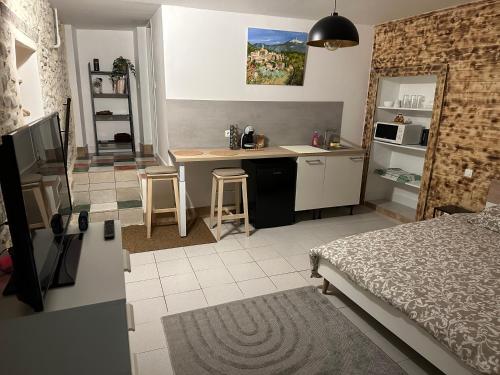 Il comprend une chambre avec un lit et une cuisine avec un bureau. dans l'établissement Studio provençale, à Mirabel-aux-Baronnies