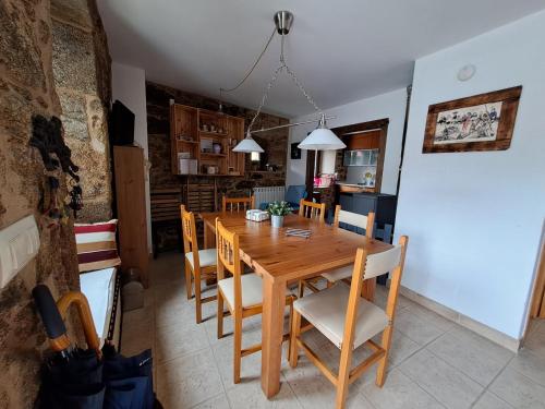 una cucina e una sala da pranzo con tavolo e sedie in legno di Casa taller de Benito a Corcubión