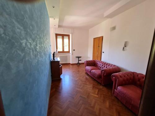 a living room with two red couches and a table at DORMI DA ME DORMI DA RE in Amandola