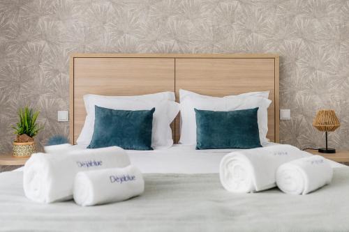 a bedroom with a large white bed with blue pillows at Blue Apartments in Leiria