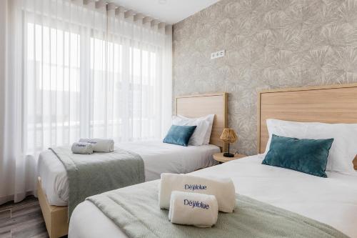 1 dormitorio con 2 camas con almohadas azules en Blue Apartments, en Leiria