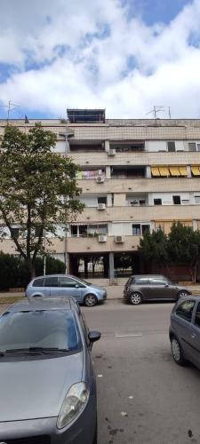 a parking lot with cars parked in front of a building at Lovely Studio with a big terrace in Belgrade
