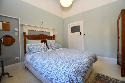 Schlafzimmer mit einem Bett mit blauer Decke in der Unterkunft Villa270 in Carterton