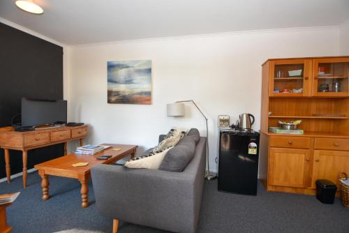 ein Wohnzimmer mit einem Sofa und einem Tisch in der Unterkunft Villa270 in Carterton