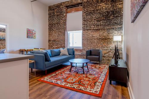 a living room with a blue couch and a brick wall at Meilleur in Galveston