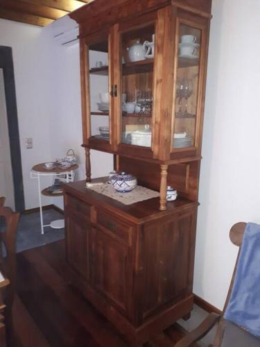 a wooden cabinet with dishes in it in a room at Quinta do Avô in Ribeira das Tainhas