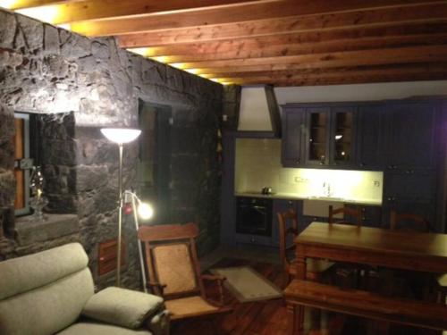Ribeira das Tainhas的住宿－Quinta do Avô，客厅设有石墙和桌子