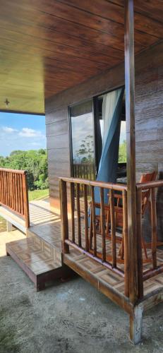 eine Veranda eines Hauses mit einer Hollywoodschaukel in der Unterkunft Cabaña de la Montaña in Río Cuarto