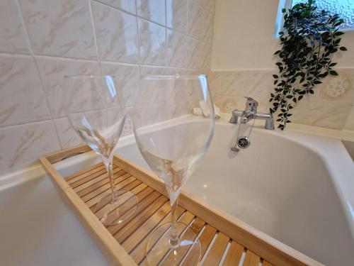 two wine glasses sitting on top of a bath tub at An Idyllic Essex Escape in Witham