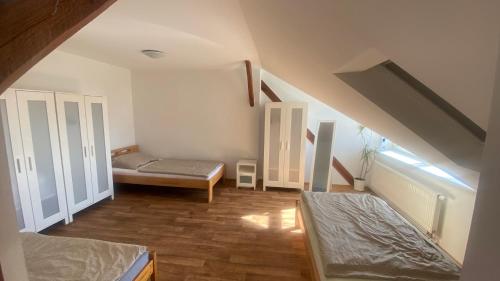 a attic room with two beds and a window at Penzion První Liga in Hradec Králové