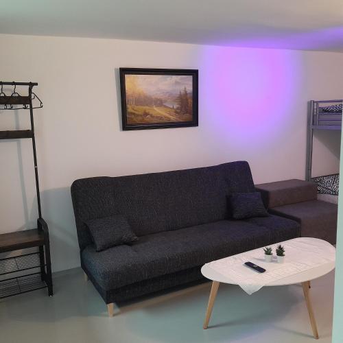 un soggiorno con un divano e un tavolo di Domek Muchorek 1km od Energylandii a Zator