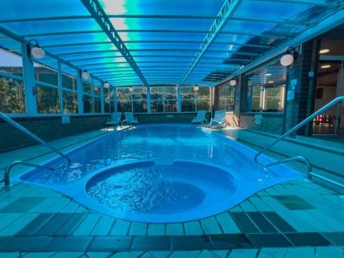 a jacuzzi tub in a building with blue lighting at Hotel Palazzo Reale in Campos do Jordão