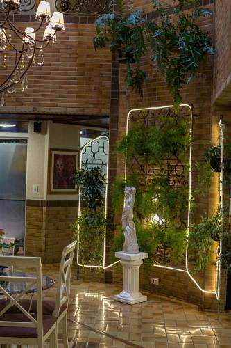 a statue in the middle of a patio with plants at Hotel Palazzo Reale in Campos do Jordão