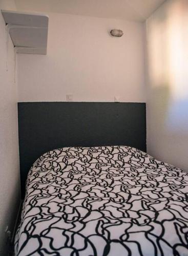 - une chambre avec un lit doté d'un couvre-lit noir et blanc dans l'établissement Appartement avec vue magnifique sur le lac marin, au Barcarès