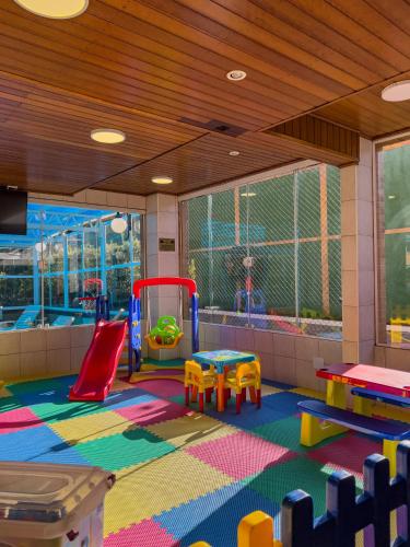 a room with a playground with tables and chairs at Hotel Palazzo Reale in Campos do Jordão