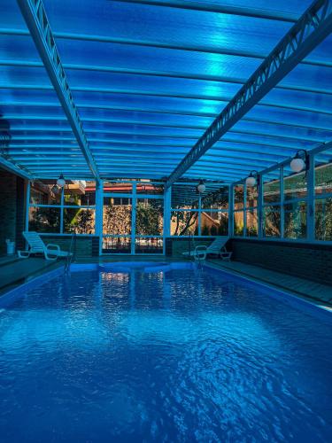 an indoor swimming pool with blue lighting in a building at Hotel Palazzo Reale in Campos do Jordão
