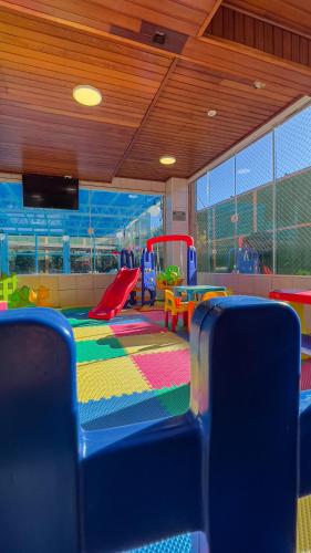 a childrens play room with a playground with a table and chairs at Hotel Palazzo Reale in Campos do Jordão