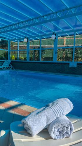 a swimming pool with a blue canopy and a towel at Hotel Palazzo Reale in Campos do Jordão