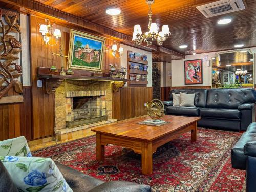 a living room with a fireplace and a table at Hotel Palazzo Reale in Campos do Jordão