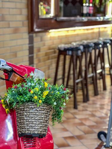 a basket on the back of a red scooter with flowers at Hotel Palazzo Reale in Campos do Jordão