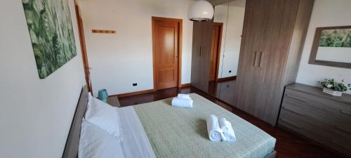 a bedroom with a bed with two pairs of shoes on it at Regina Ciclarum Suite in Fiumicino