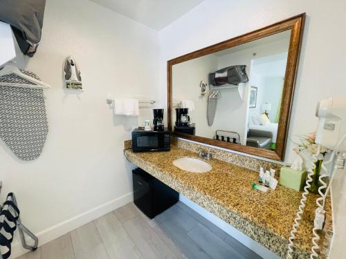 a bathroom with a sink and a mirror at Loma Linda Inn in San Bernardino