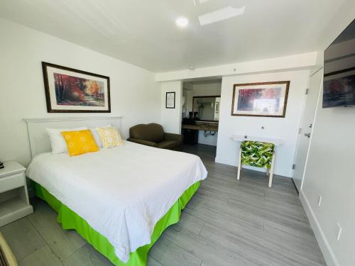1 dormitorio con 1 cama y 1 silla en Loma Linda Inn, en San Bernardino