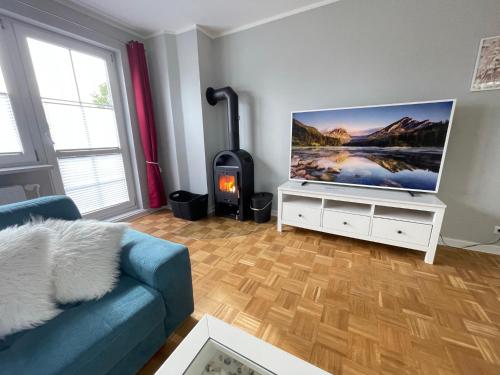 a living room with a blue couch and a flat screen tv at Wohlfuehl-Orte24 am Hafen in Schaprode, Rügen in Schaprode