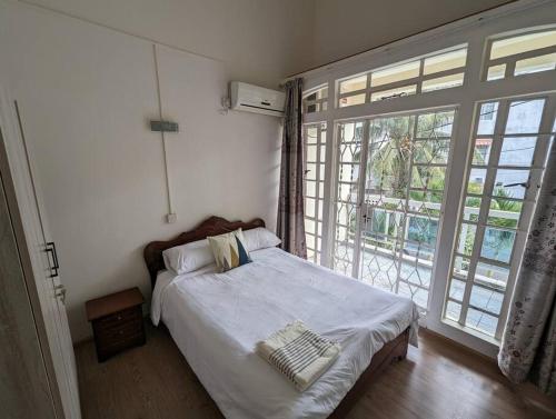 a bedroom with a bed and a large window at Villa Coco - Flic en Flac in Flic-en-Flac
