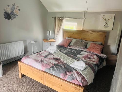 1 dormitorio con 1 cama grande y cabecero de madera en Daffodil Lodge, en Sligo
