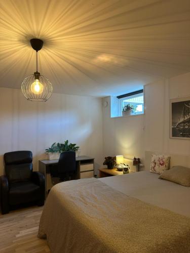 a bedroom with a bed and a chair and a window at Spacious private room in a Vegan household in Gothenburg