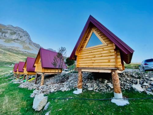 een rij houten hutten op een rotsachtige heuvel bij Kapetanovo Jezero Bungalov in Podgorica