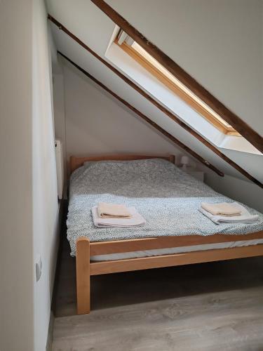 a bed in a small room with two towels on it at Old Town apartments in Novi Sad