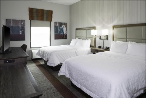 a hotel room with two beds and a flat screen tv at Hampton Inn & Suites Pittsburg Kansas Crossing Casino near Pitt State Univ in Pittsburg