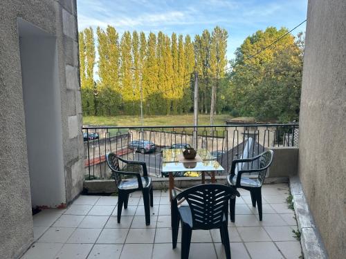 un patio avec une table et des chaises sur un balcon dans l'établissement Appartement proche de la gare, à Bourges