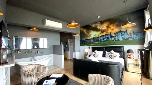 a bedroom with a bed and a bathtub and a painting at The Clarendon Hotel in Deal