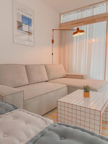 salon z kanapą i stołem w obiekcie NØDA - Nørdic Design Apartment with Terrace w Liptowskim Mikulaszu