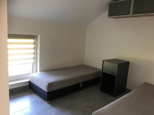 niewielka sypialnia z łóżkiem i oknem w obiekcie Kris Pokoje w mieście Kajetany