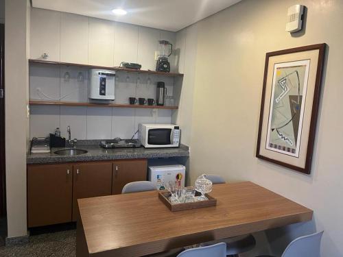 a kitchen with a table with chairs and a microwave at Apto setor central 808 in Goiânia