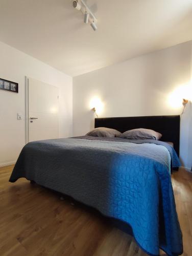 1 dormitorio con 1 cama grande con manta azul en 'BRIGHT 201' Moderne, helle Wohnung in BI Zentrum, 400 m bis Lokschuppen, Smart-TV, WLAN, en Bielefeld