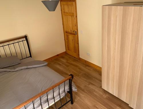 1 dormitorio con 1 cama y puerta de madera en Seventy Eight, en Wexford