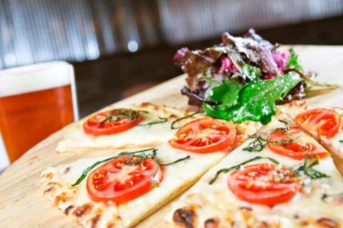 a table with two pizzas with tomatoes and a salad at Wyndham Garden York in York