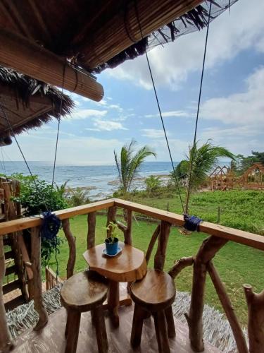 a balcony with a table and chairs and the ocean at Almare Guest House Siquijor in San Juan