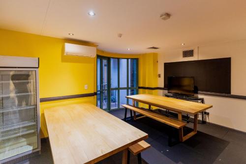 The Social Hotel, Sydney في سيدني: غرفة مع طاولة وتلفزيون بشاشة مسطحة