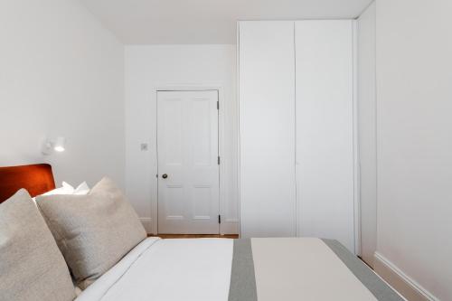 a white bedroom with a bed and a white door at FOX ON THE HOE in Plymouth