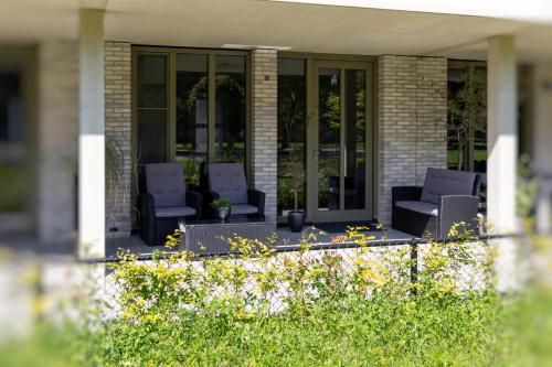 een veranda met twee stoelen op een huis bij Luxury room with king size bed in Dordrecht
