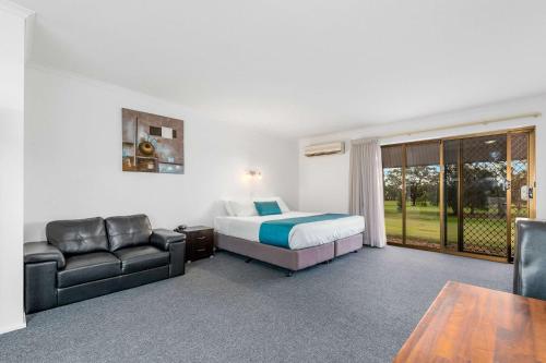 Comfort Inn & Suites Riverland في Barmera: غرفه فندقيه بسرير واريكه